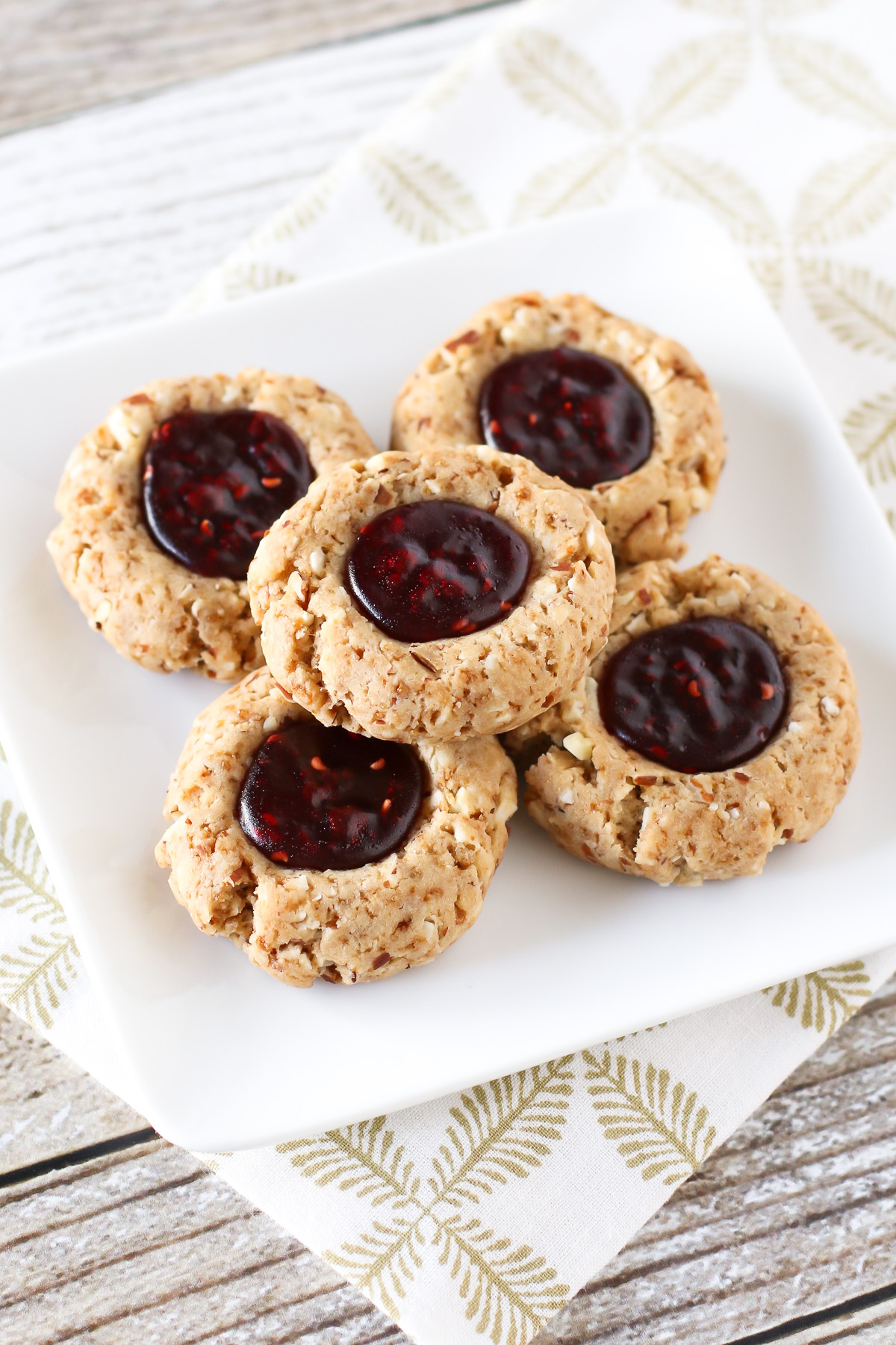 Gluten Free Vegan Raspberry Thumbprint Cookies. Tender almond cookies with a raspberry jam filling. A holiday classic!