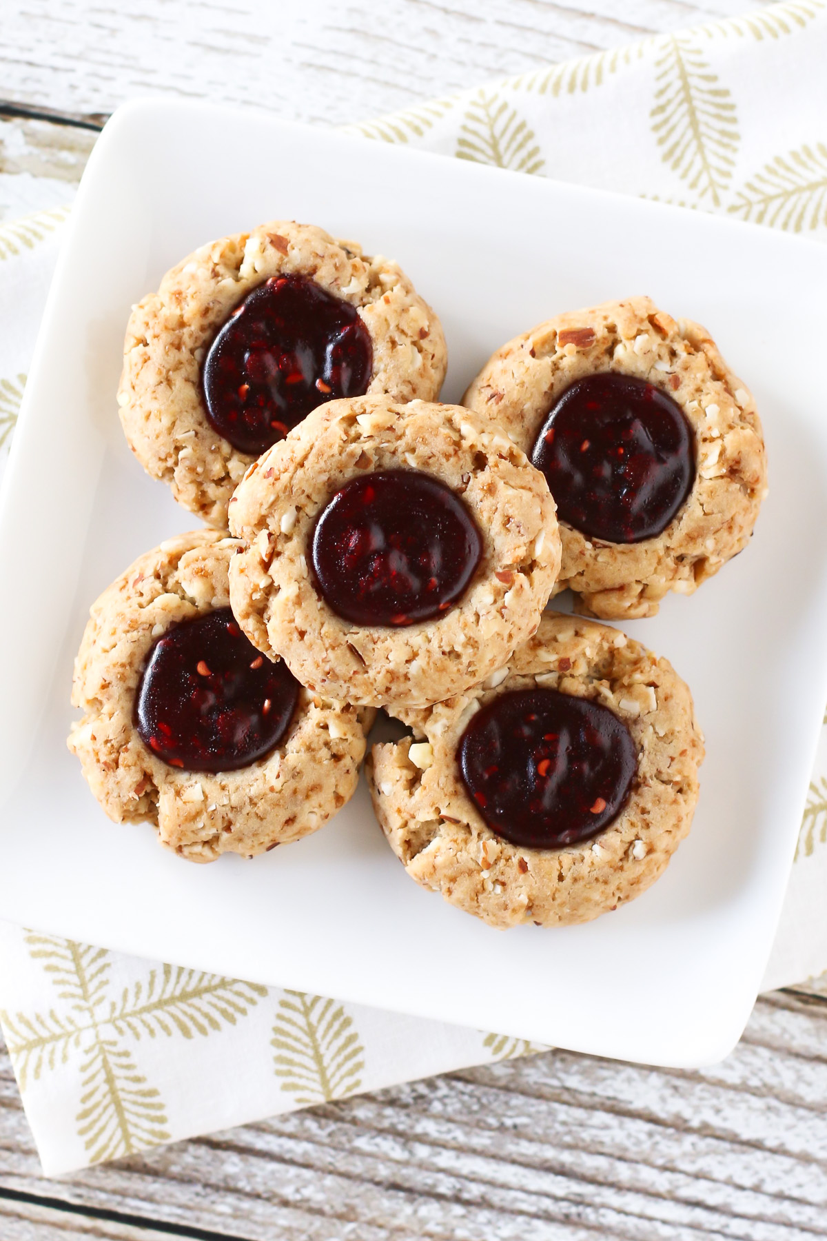 Gluten Free Vegan Raspberry Thumbprint Cookies. Tender almond cookies with a raspberry jam filling. A holiday classic!