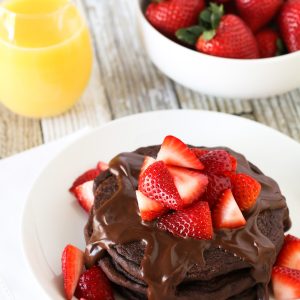 Gluten Free Vegan Double Chocolate Pancakes. Fluffy chocolate pancakes, covered in a simple chocolate sauce and fresh strawberries. Quite the decadent breakfast!