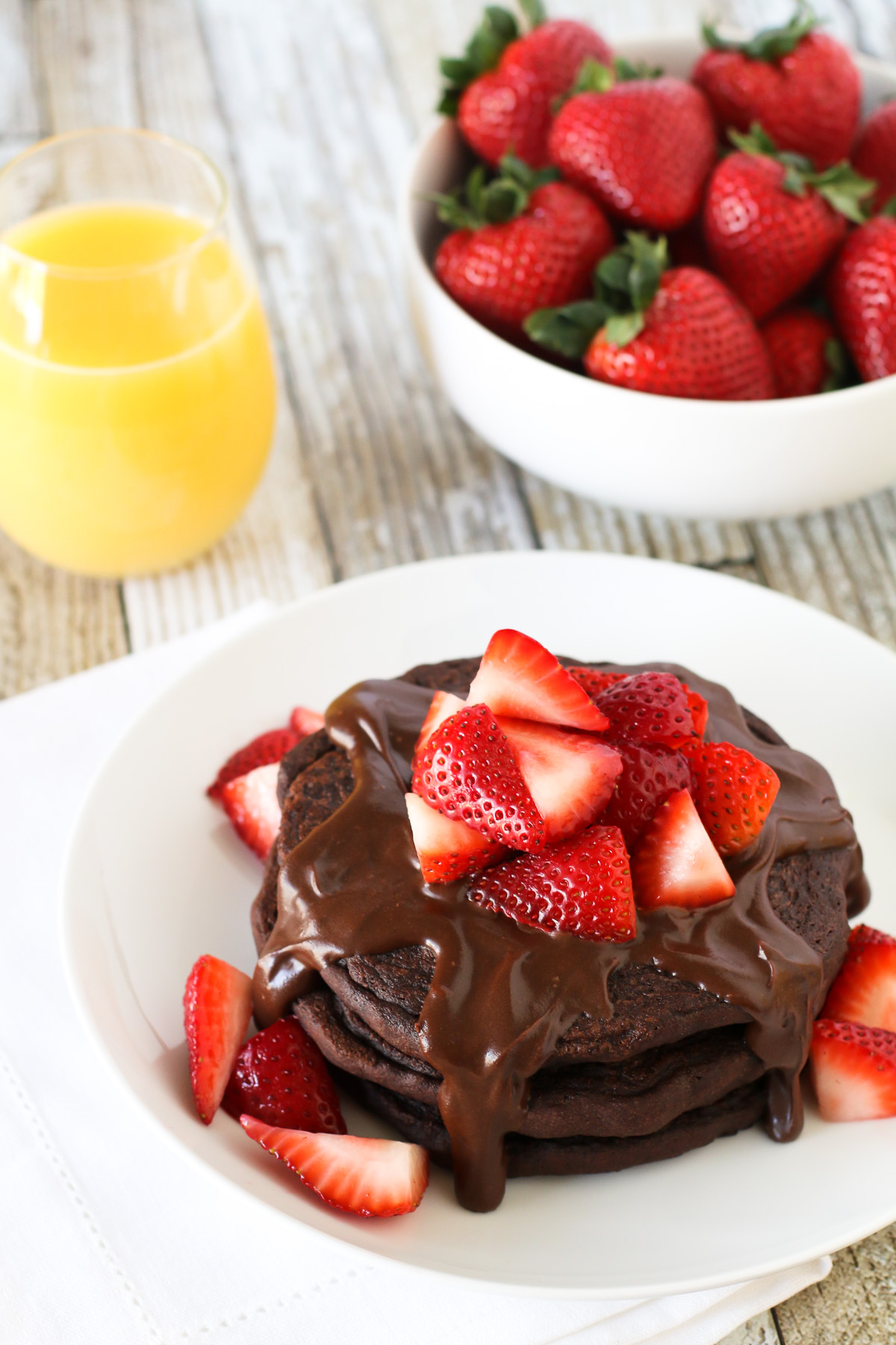 Gluten Free Vegan Double Chocolate Pancakes. Fluffy chocolate pancakes, covered in a simple chocolate sauce and fresh strawberries. Quite the decadent breakfast!