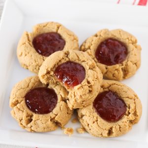 Gluten free vegan peanut butter and jelly thumbprint cookies. Soft peanut butter cookies, filled with your favorite berry jam. The classic combo in a cookie!