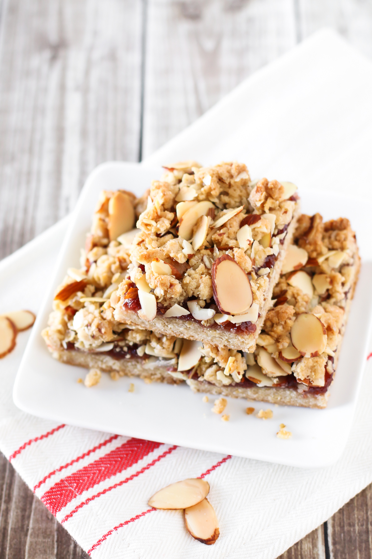 Gluten Free Vegan Raspberry Almond Crumb Bars. Layers of crumb topping, sweet raspberry jam and toasted almonds. The perfect bite!