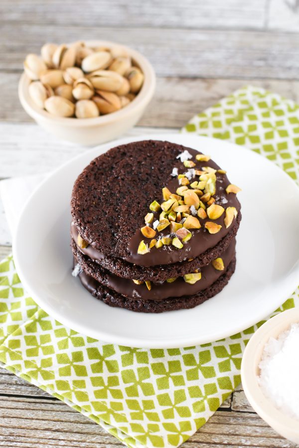 Grain Free Vegan Sea Salt Pistachio Chocolate Cookies. Chewy chocolate almond cookies, dipped in chocolate and sprinkled with chopped pistachios and sea salt.