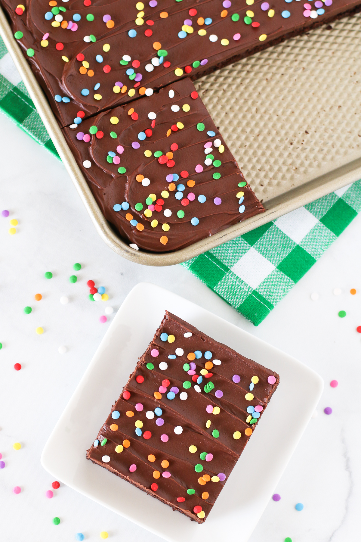Gluten Free Vegan Chocolate Frosted Brownies. Fudgy, chocolate frosted brownie with colorful sprinkles. The perfect chocolate treat for any celebration!