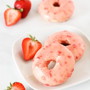 Gluten Free Vegan Baked Strawberry Donuts. Tender baked vanilla donuts with a fresh strawberry glaze. So pretty!