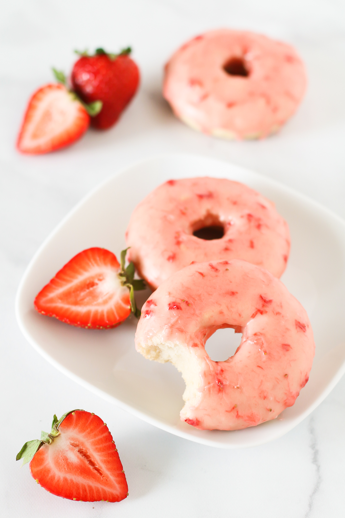Gluten Free Vegan Baked Strawberry Donuts. Tender baked vanilla donuts with a fresh strawberry glaze. 