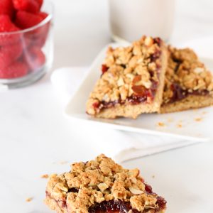 Gluten Free Vegan Raspberry Almond Breakfast Bars. These almond oat bars are slightly sweetened and filled with raspberry jam. A lovely on-the-go breakfast treat.