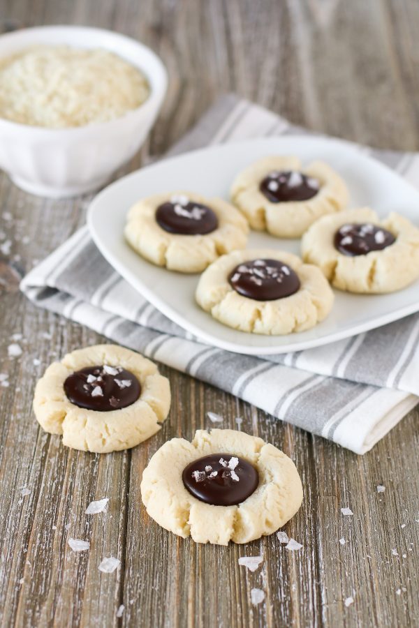 Gluten Free Vegan Salted Chocolate Almond Thumbprint Cookies. Soft almond thumbprint cookies, filled with a decadent chocolate ganache and topped with beautiful sea salt flakes.