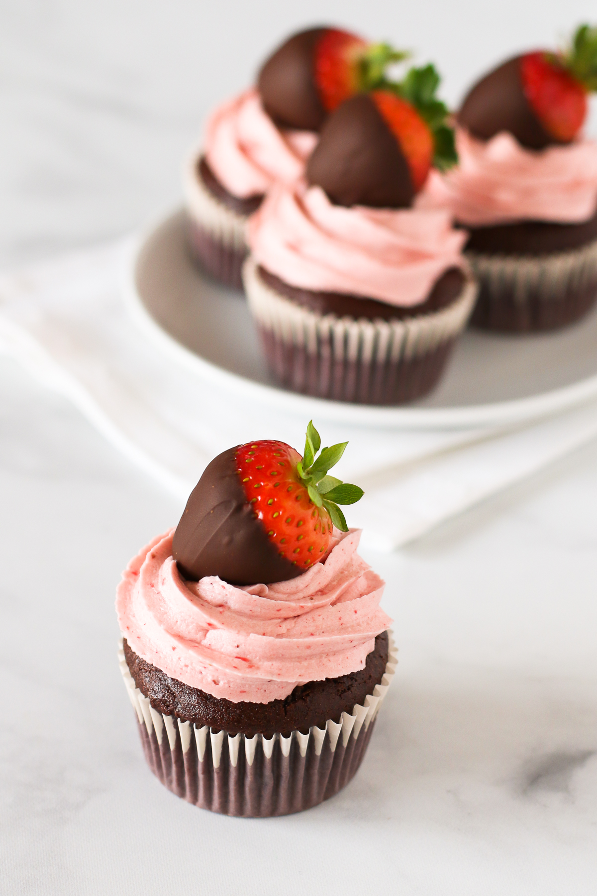 Gluten Free Vegan Chocolate Covered Strawberry Cupcakes. Chocolate cupcakes with a fluffy strawberry buttercream, topped with a beautiful chocolate covered strawberry.