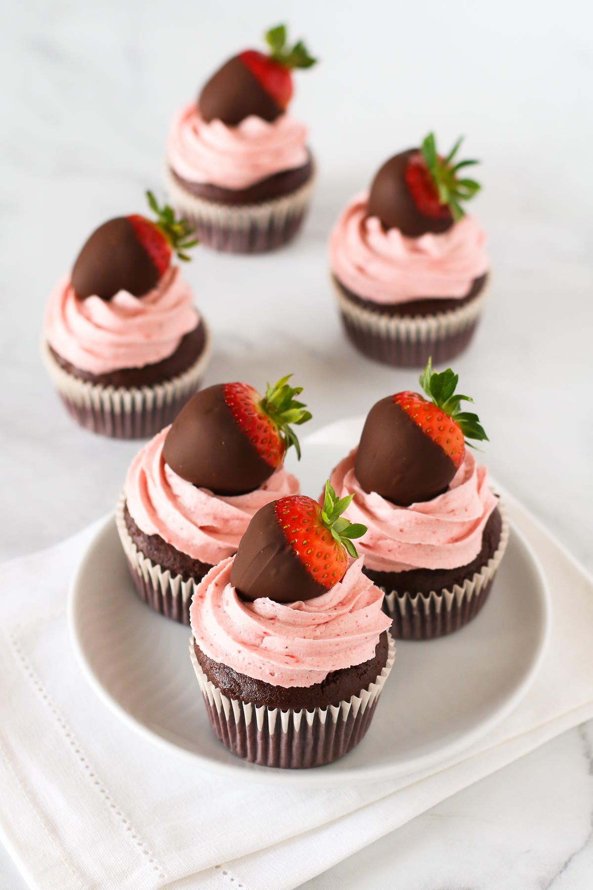 Gluten Free Vegan Chocolate Covered Strawberry Cupcakes. Chocolate cupcakes with a fluffy strawberry buttercream, topped with a beautiful chocolate covered strawberry.