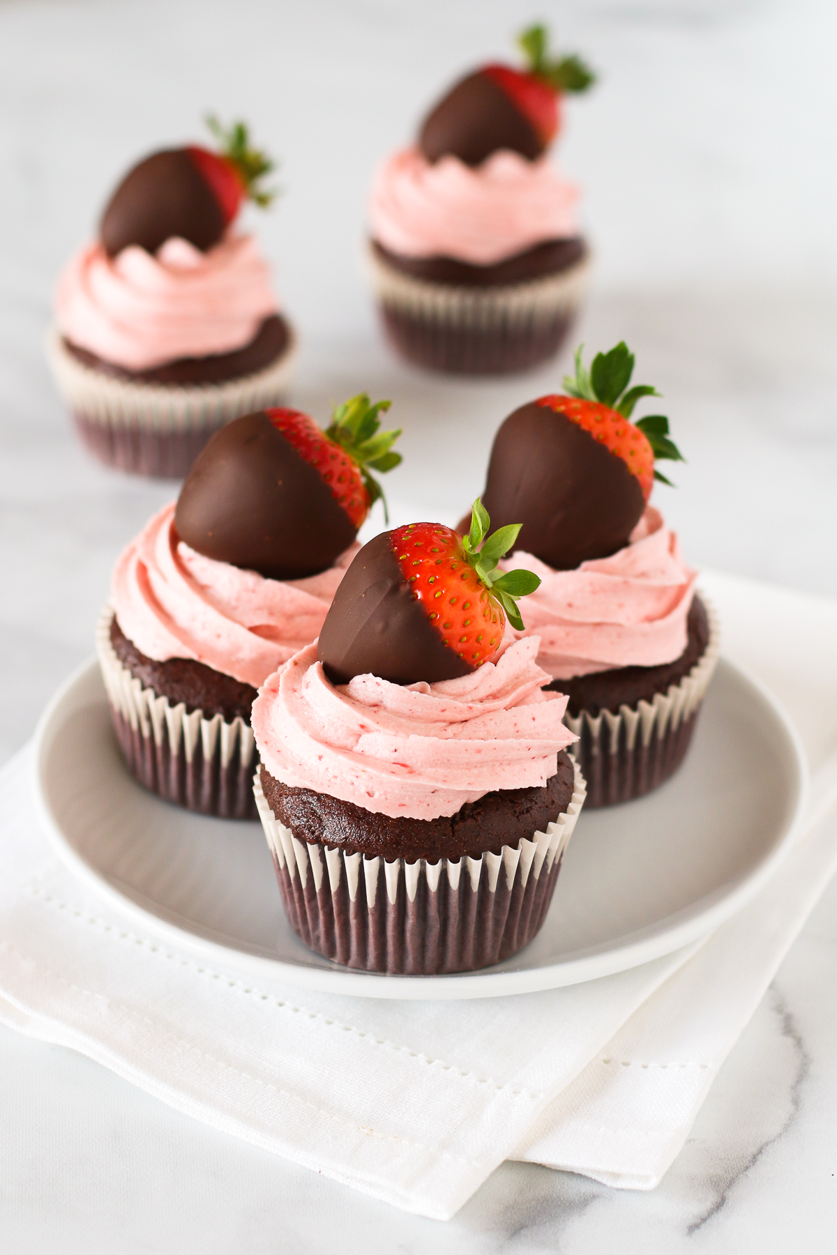 Gluten Free Vegan Chocolate Covered Strawberry Cupcakes. Chocolate cupcakes with a fluffy strawberry buttercream, topped with a beautiful chocolate covered strawberry.