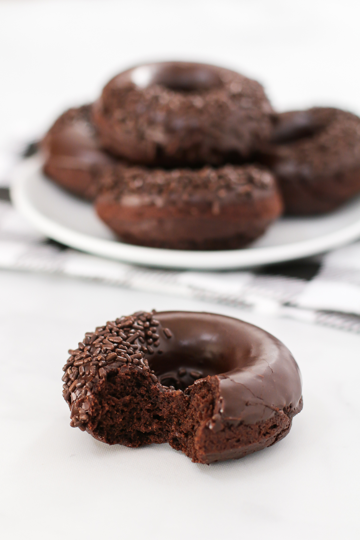 Gluten Free Vegan Baked Chocolate Donuts. Who can resist a chocolate cake donut, dipped in a decadent chocolate glaze and topped with chocolate sprinkles?