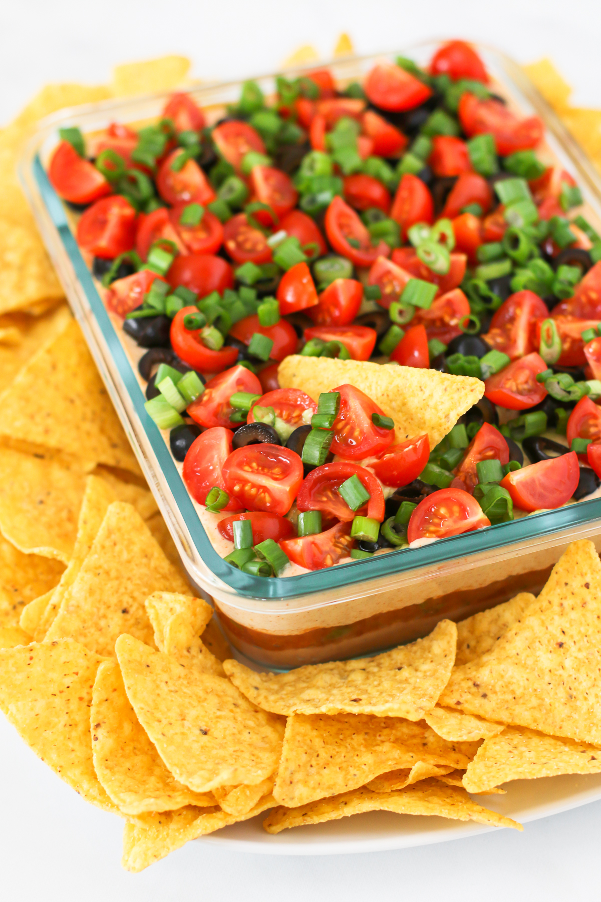 Vegan 7 Layer Bean Dip. Layers of beans, guacamole, creamy taco sauce, salsa and all of the vibrant Mexican flavors.