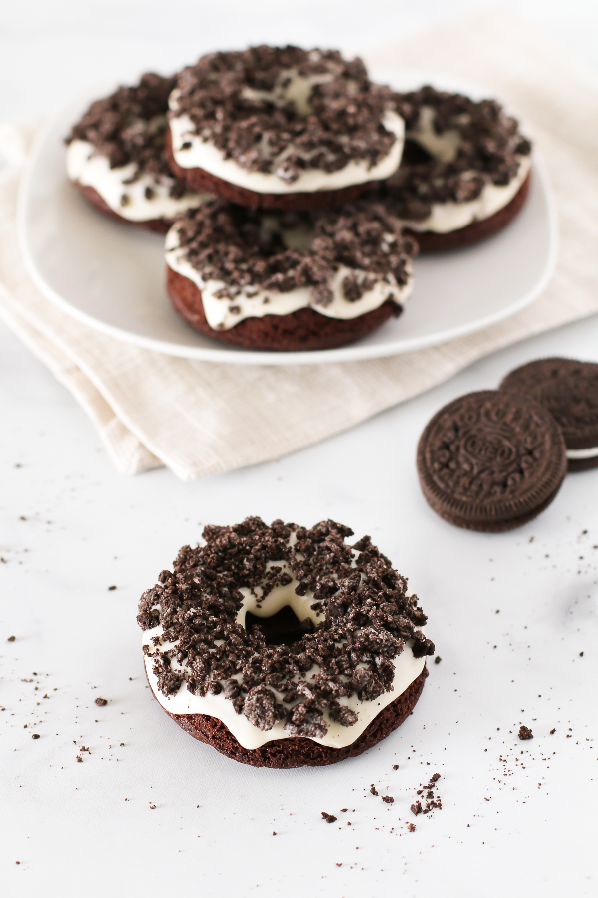 Gluten Free Vegan Cookies N’ Cream Donuts. These baked chocolate donuts have a simple vanilla glaze and are covered with lots of crushed Oreo cookies!