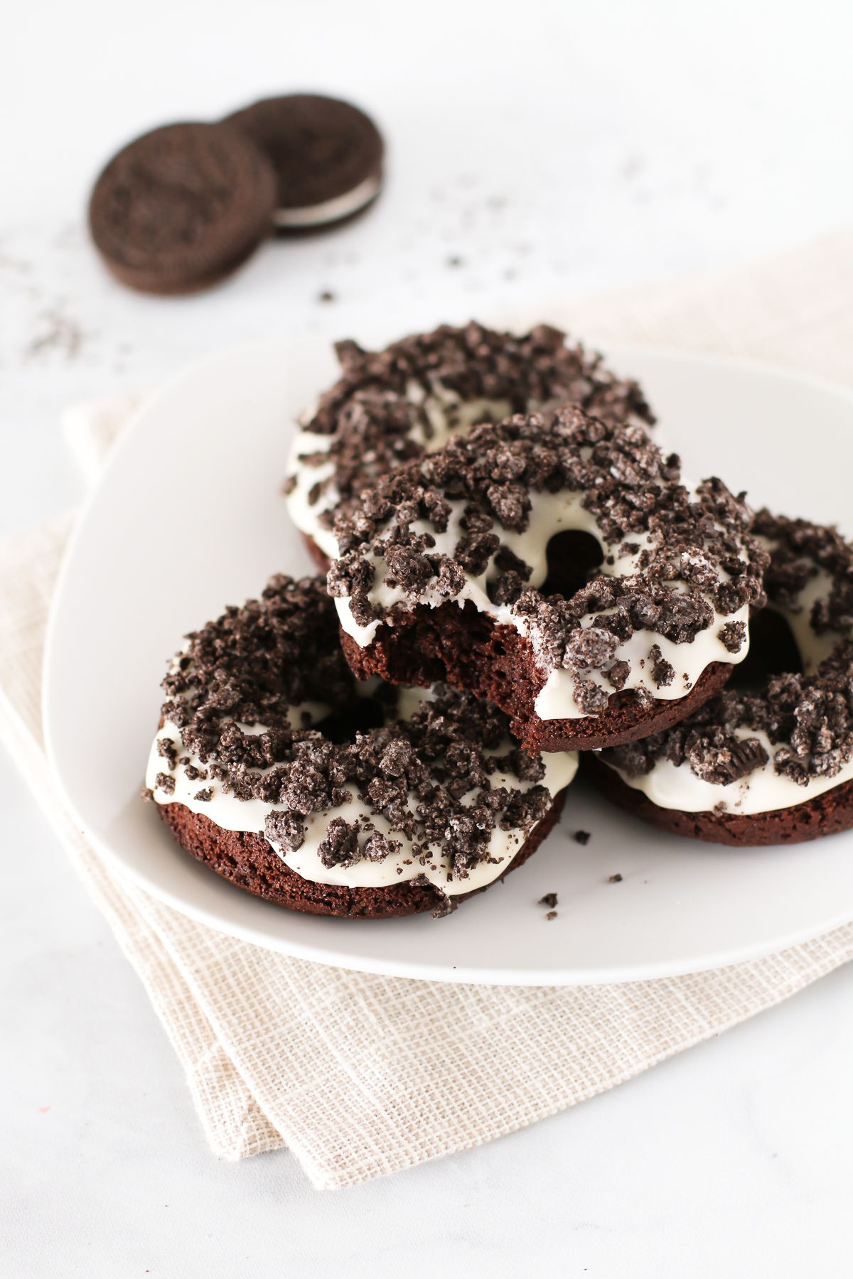 Gluten Free Vegan Cookies N’ Cream Donuts. These baked chocolate donuts have a simple vanilla glaze and are covered with lots of crushed Oreo cookies!